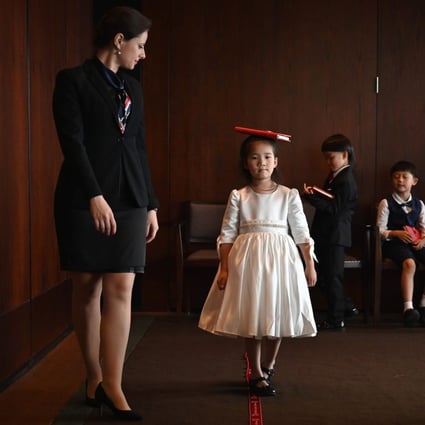 Miona Milakov guides Zoey Zhang on how to walk during an etiquette and manners class in central Shanghai. Photo: AFP