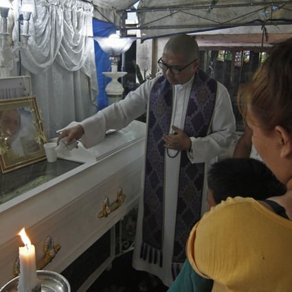 Fr. Flavie Villanueva, SVD, blesses the casket of 34 year old Jerito Garganta after he was shot and killed by unknown assailants along Kawal St., district 28, Caloocan City on the night of May 6, 2019. Photo: Vincent Go