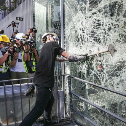 Demonstrators smash windows of the Legislative Council Complex in Tamar on Monday during a protest against the extradition bill. Photo: Sam Tsang