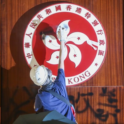 A protester defaces the Hong Kong emblem in the Legislative Council chamber. Photo: Winson Wong