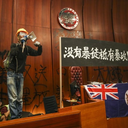 Protesters display a banner reading: ‘There are no rioters, but a tyrannous government’ after occupying the Legislative Council chamber. Photo: Winson Wong