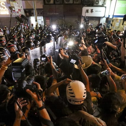 Riot police facing a media crowd as they clear Nathan Road during Sunday’s protests. Photo: Felix Wong