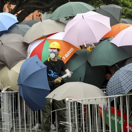 Protesters use umbrellas to protect themselves on Sunday as they face-off with riot police after a march in Sha Tin. Photo: Felix Wong