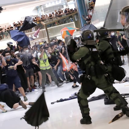 Riot police use pepper spray to disperse protesters in Hong Kong who returned fire with umbrellas and bottles. Photo: Reuters