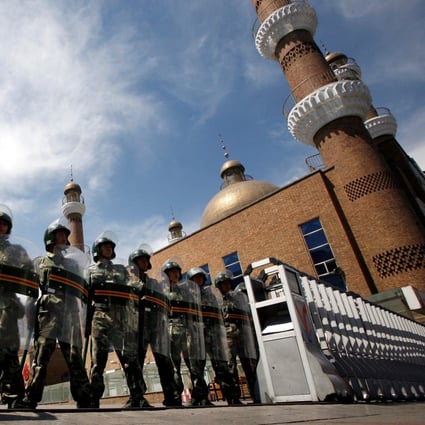 Chinese paramilitary police in riot gear stand guard at the entrance to a large mosque in the centre of Urumqi, in China’s Xinjiang Autonomous Region, in July 2009. Photo: Reuters