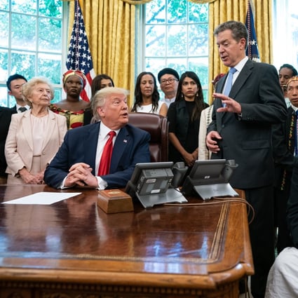 Donald Trump and his envoy for religious freedom Samuel Brownback (standing) meet victims of religious persecution in the Oval Office, including Jewher Ilham (far right). Photo: EPA-EFE