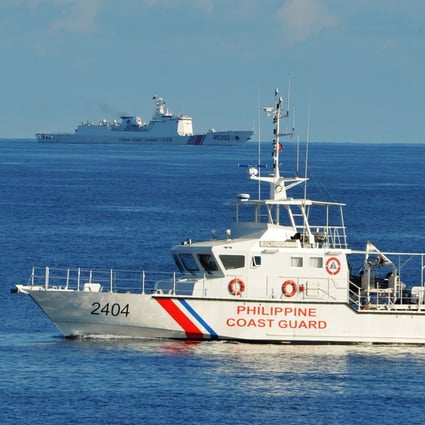 A Philippine coastguard ship sails past a Chinese coastguard vessel during a Philippine-US rescue exercise near the Scarborough Shoal in the South China Sea. Photo: AFP