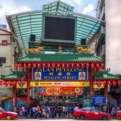 Crowds pass below the main gate of Petaling Street, now home to a slew of trendy cafes, restaurants and bars. Photo: Shutterstock