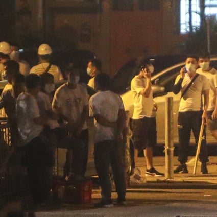Men wearing white T-shirts and wielding weapons stand on the streets of Yuen Long on Sunday night, which descended into mob violence. Photo: Winson Wong