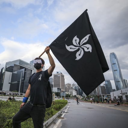A protester holding up a black Hong Kong flag while marching against the extradition bill outside the Legislative Council in Tamar, Admiralty, on the 22nd anniversary of Hong Kong’s handover from Britain to China on July 1. Photo: Winson Wong