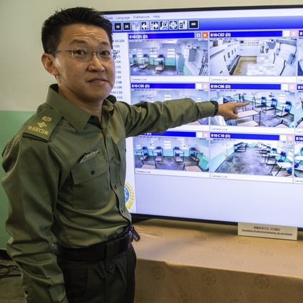 A prison guard demonstrates a high tech AI video analytics system developed by Wildfaces Technology being used at Pik Uk prison in Sai Kung, Hong Kong. Photo: EPA-EFE