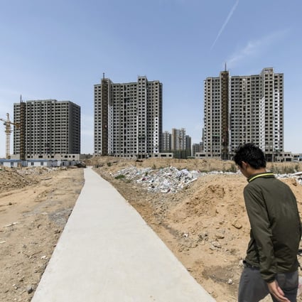 A worker walks towards residential buildings under construction in Qingdao, China, on May 8, 2018. Upgraded property curbs have hit sales in the northern mainland city. Photo: Bloomberg