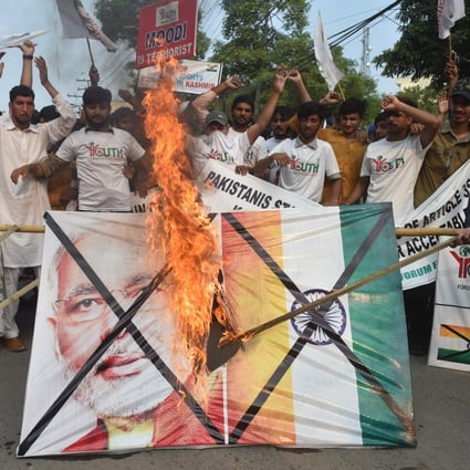 Pakistani activists burn a picture of Indian Prime Minister Narendra Modi and the Indian flag in Lahore to protest the Kashmir move. Photo: AFP