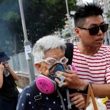 An elderly woman is helped by a demonstrator after police fire tear gas during a protest in Tin Shui Wai on August 5. Photo: Reuters