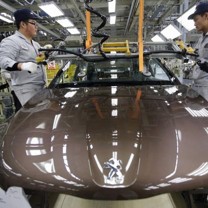 Workers on a production line at Dongfeng Peugeot Citroen Automobile in Wuhan, Hubei province on February 13, 2014. Photo: Reuters