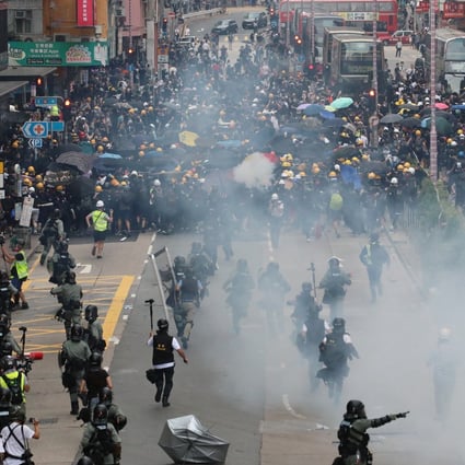 Riot police run towards anti-government protesters in Sham Shui Po during another day of clashes across Hong Kong on Sunday. Photo: Felix Wong