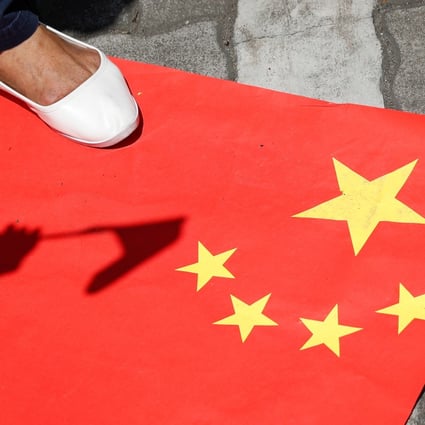 An activist outside the Department of Foreign Affairs in Manila steps on a paper Chinese flag during a protest against the sinking of a fishing boat. Photo: EPA