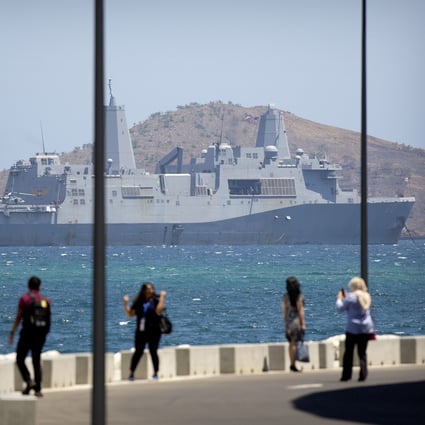 Visitors pose for photos outside Apec Haus in Papua New Guinea in November, with the USS Green Bay anchored just offshore in Port Moresby. Photo: AP