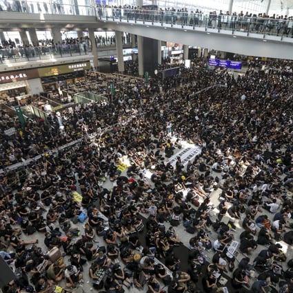 Protesters hold a sit-in at Hong Kong International Airport on Monday. As many as 272 flights were cancelled in two days of protests. Photo: Felix Wong