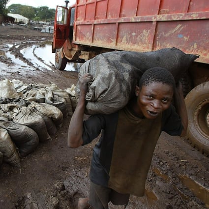 A worker carries wet cobalt on his back at a mine in the Democratic Republic of Congo. Photo: AP