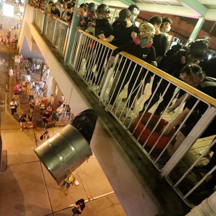 Anti-government protesters drop a rubbish bin on riot police from a footbridge in Mong Kok. Photo: Felix Wong