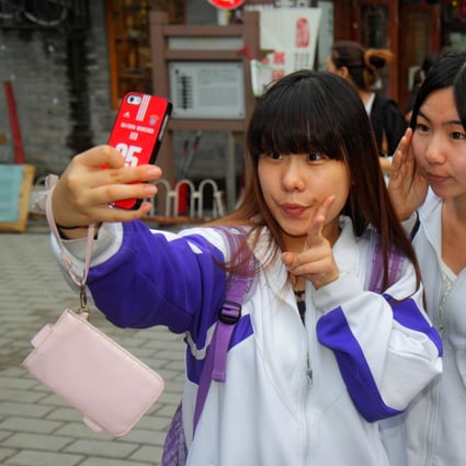 Students taking photos at Beijing’s Nanluo Guxiang historic street.