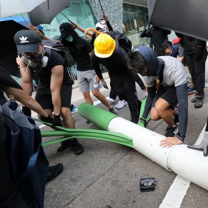 Anti-government protestors disassemble a smart lamp post near the Zero Carbon Building, Kowloon Bay on Saturday. Photo: Dickson Lee