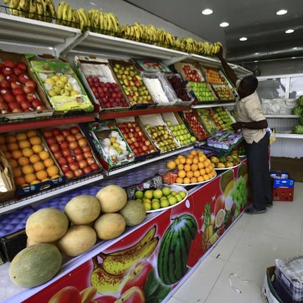 A fruit seller organises fresh produce at a shop in the Sudanese city of Omdurman. Many countries, in particular in Africa, rely on bananas for over a quarter of their daily calorie intake. Photo: AFP