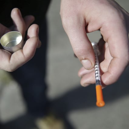 A US fentanyl user holds a needle used to inject the drug. Photo: AP