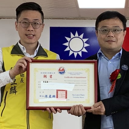 Lee Meng-chu (right) receives a certificate for his work with the Fangliao township in Taiwan from mayor Chen Ya-lin in June. Photo: AP
