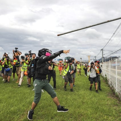 A protester launches a pole onto the tracks of the Airport Express. Photo: Sam Tsang