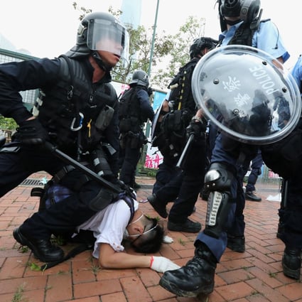 Police in riot gear restrain a protester outside the Legislative Council building in June. Photo: Felix Wong