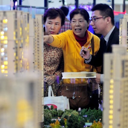 Visitors looking at building models at a real estate and home decorations expo in Fuzhou, capital of southeast China's Fujian province on November 16, 2012. Photo: Xinhua