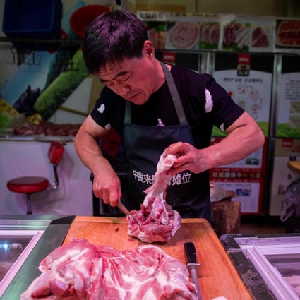 A butcher cuts a piece of porc meat at his stall at a market in Beijing. China's pork industry has been left reeling from African swine fever, which has devastated its pig herd, sent pork prices soaring and forced the country to increase imports to satisfy demand. Photo: AFP