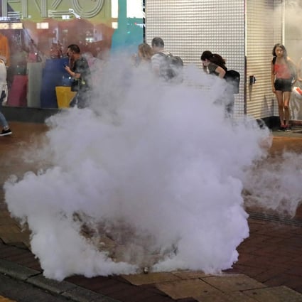 People run as police fire tear gas in Hong Kong on Sunday. Photo: AP