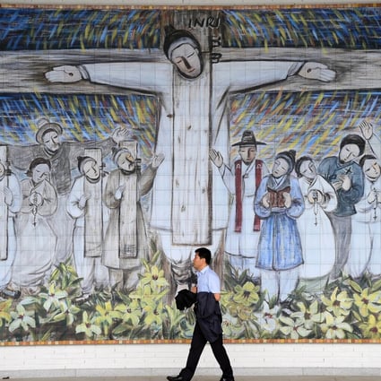 A man passes in front of a huge wall painting for South Korea’s Catholic martyrs at Solmoe Shrine in Dangjin, 85km southwest of Seoul. Photo: AFP