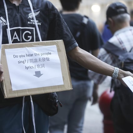 A protester handing out the lyrics to ‘Do You Hear The People Sing?’ ahead of the football match between Manchester City and Kitchee at Hong Kong Stadium on July 24. Photo: Winson Wong