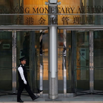 An attendant walks outside the entrance to the Hong Kong Monetary Authority offices in November 2015. Photo: Reuters