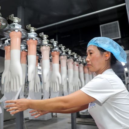 An employee working on a medical glove production line at a factory in Huaibei in China's eastern Anhui province. Photo: AFP