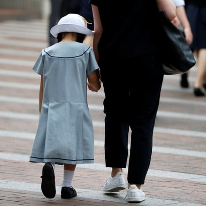 A student and her mother enter a school in Kawasaki, Japan. Photo: Reuters