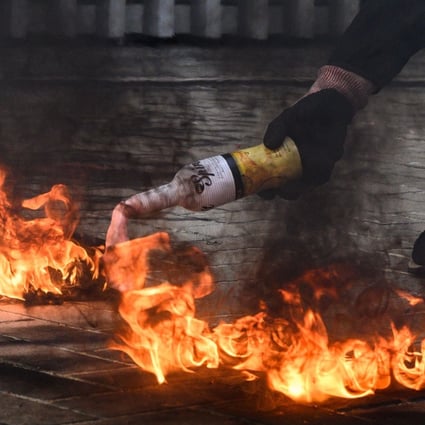 A protester lights a petrol bomb before throwing it at police stationed outside government headquarters in Hong Kong on Sunday. Photo: AFP