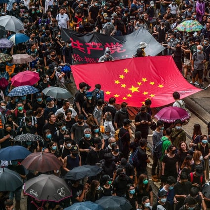 Protesters march through Central on August 31 with a banner on which the stars of the Chinese flag have been rearranged into a Nazi swastika. Photo: AFP