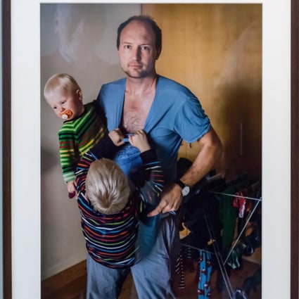 Hanging on to Dad by Johan Bävman, part of his exhibition celebrating Swedish fathers caring for their babies and toddlers on paternity leave. Photo: Tommy Lindholm/Pacific Press/Alamy