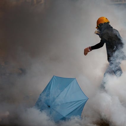 A Hong Kong protester walks in a cloud of tear gas. Photo: Bloomberg