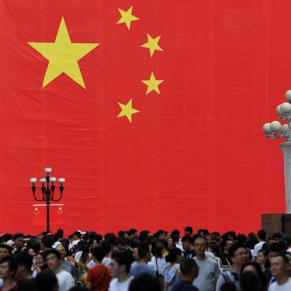 People walk in front of a giant Chinese flag ahead of the 70th anniversary of the People's Republic China in Chongqing, China September 13, 2019. Photo: Reuters