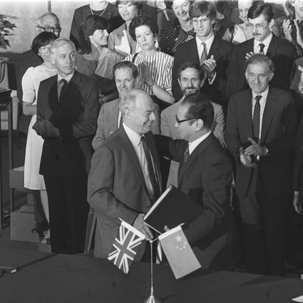 Sir Richard Evans (left), the British ambassador to China, and Zhou Nan, chairman of the Chinese negotiating team, exchange documents after signing a draft of the joint declaration. Photo: P.Y. Tang