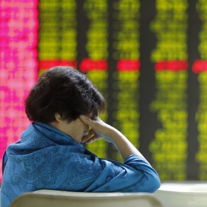 A Chinese investor in front of an electronic board showing stock prices at a Beijing brokerage on 2 August 2019. Contrary to global conventions, China’s financial markets represent losses and declines in green, using red to denote gains and advances. Photo: EPA-EFE