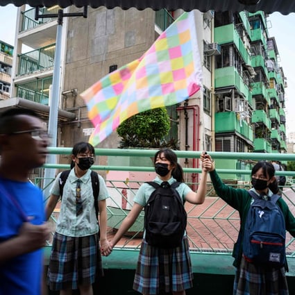 A student holds a “Lennon Wall flag”, designed by Australia-based Chinese political artist Badiucao, as she and others join hands to form a human chain in Hong Kong’s Kwun Tong district, on September 24. Photo: AFP