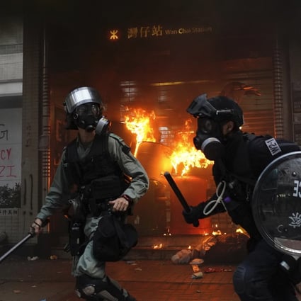 Riot police arrive after protesters start a fire at the exit to Wan Chai MTR station and vandalise public property in Hong Kong on September 29. Police fired tear gas on the day in the Causeway Bay, after a large crowd of protesters ignored warnings to disperse. Photo: AP
