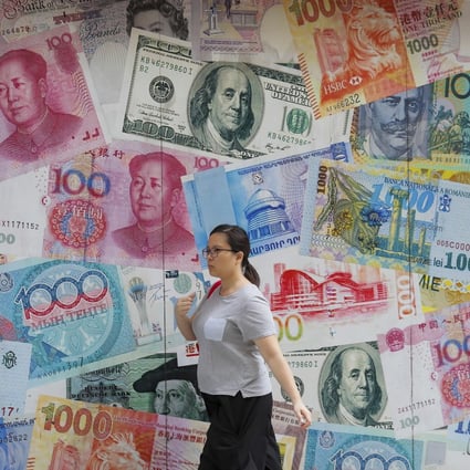 A woman walks by a money exchange shop decorated with various banknotes at Central. Overall currency deposits in Hong Kong’s banking system edged up by 0.2 per cent month on month in August. Photo: AP Photo